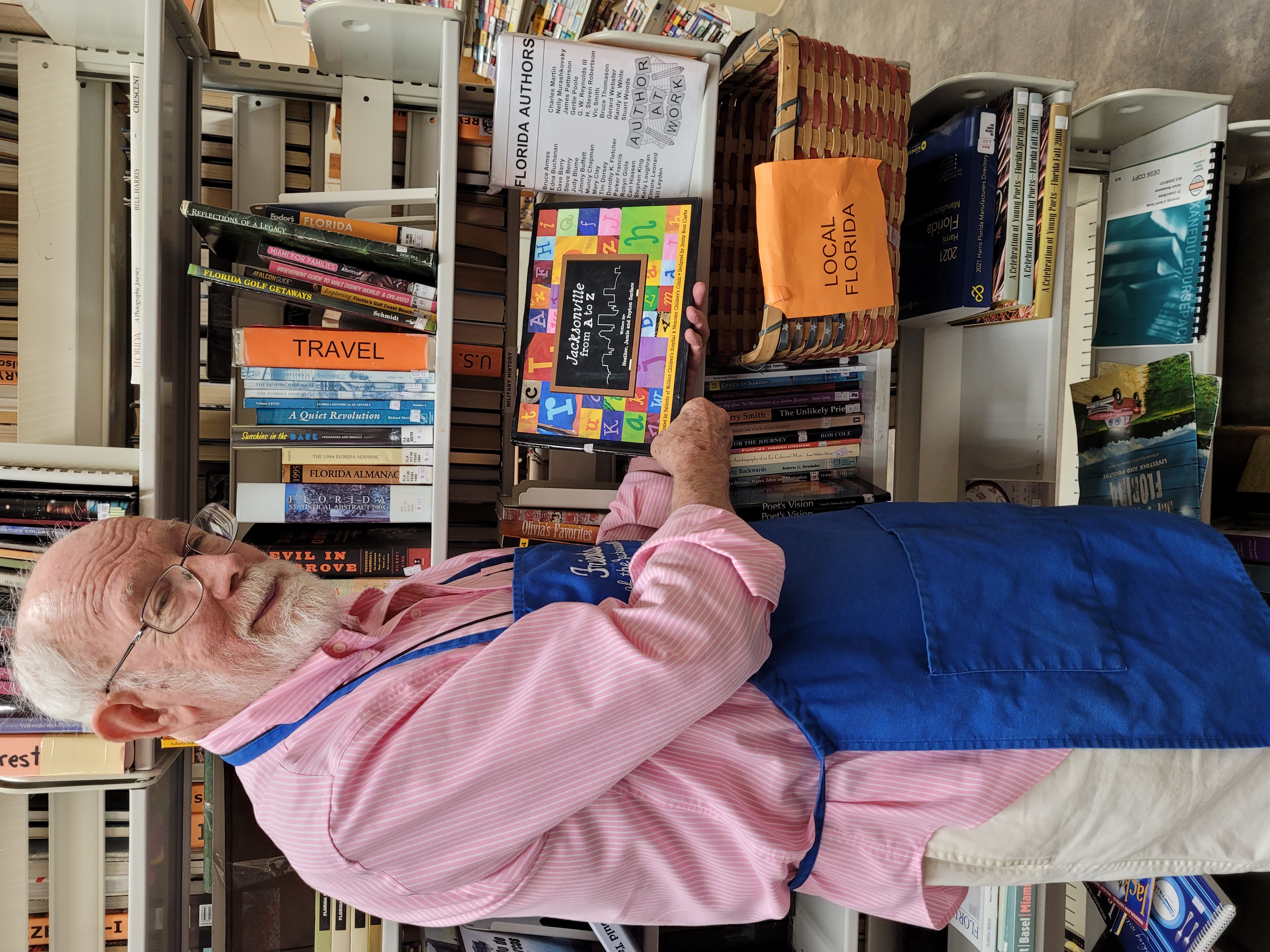 Book store volunteer holds a book titled "Jacksonville from A to Z"