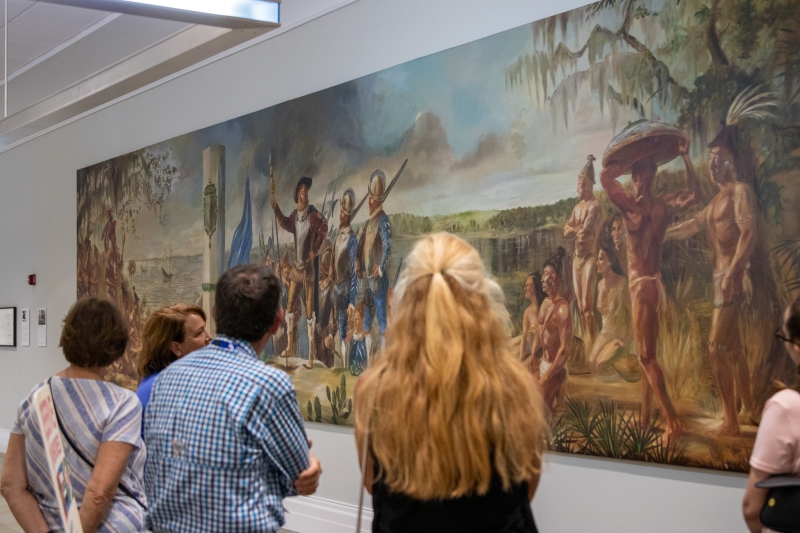 A small group tour in front of the Ribault mural